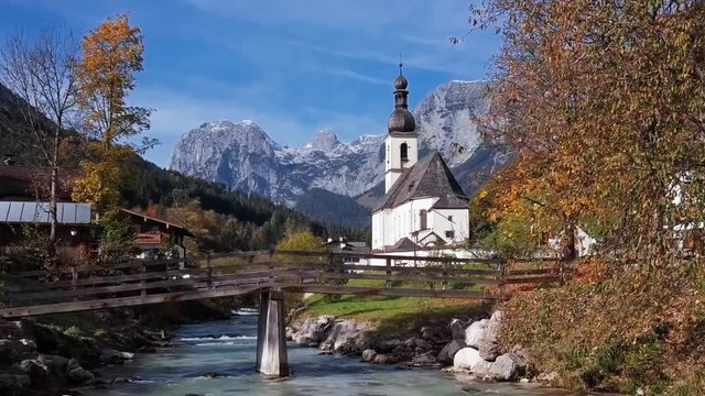 Flight over footbridge near famous Parish church St. Sebastian, in Ramsau, Berchtesgaden, Bavarian Alps Germany.