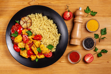 Mexican cuisine. Rice with black sesame. Spicy chicken with curry, paprika, cherry tomatoes and...