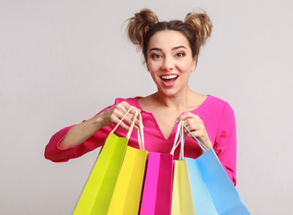 Happy woman posing with shopping bags and looking at camera