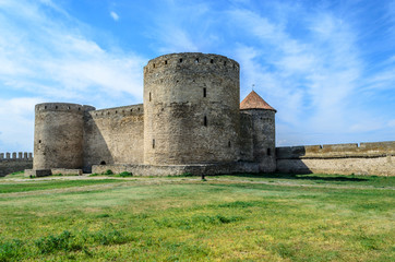 Fototapeta na wymiar Medieval castle by the sea, surrounded by green grass. Krupost, fortification in Eastern Europe, Ukraine, Odessa region. Belgorod-Dniester fortress. The dwelling of knights and lords. Ackermann.