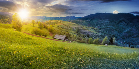 time change above the rural field with dandelions in mountains. beautiful springtime landscape with sun and moon. village in the distance valley.