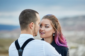 Fototapeta premium Valentine's day loving couple in nature hugs and kisses, man and woman love each other. Mountains of Cappadocia in Turkey beautiful couple celebrates Valentines day, lover couple mountains background