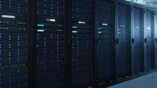 Moving Walkthrough Shot of Modern Data Center With Multiple Rows of Fully Operational Server Racks. Modern High-Tech Telecommunications Database Super Computer in a Room.