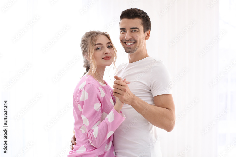 Poster cute young couple dancing on light background