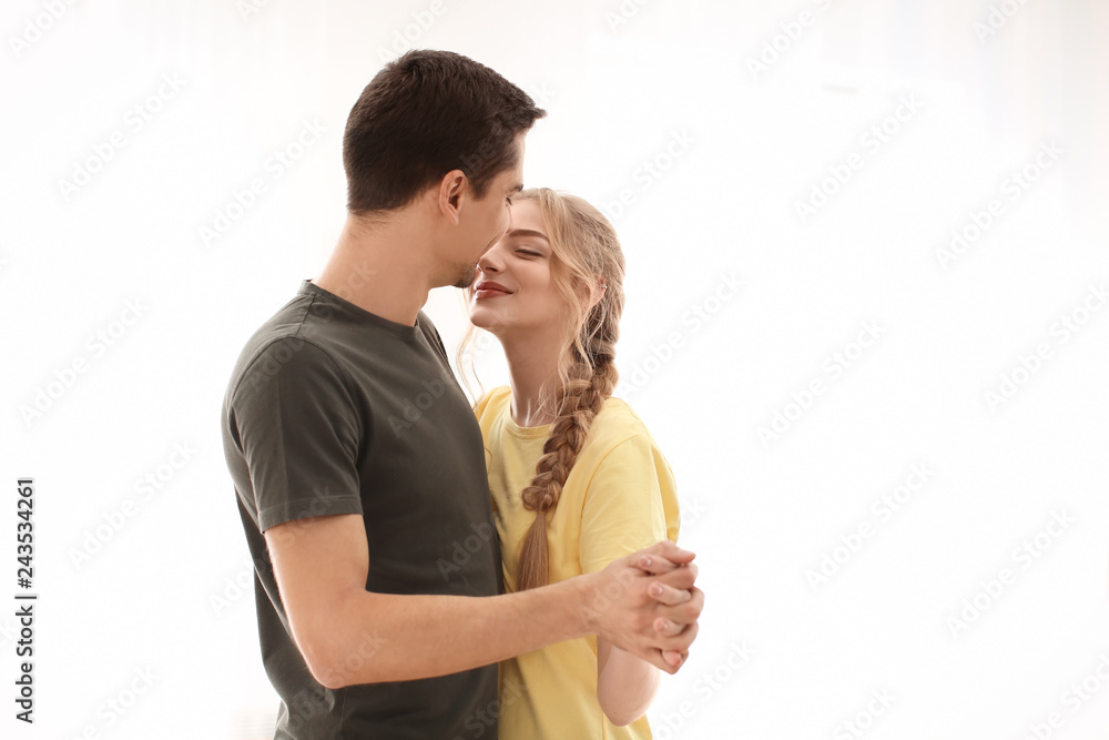 Poster cute young couple dancing on light background