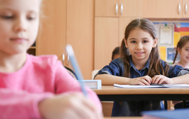 Cute children doing homework in classroom at school