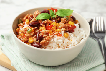 Tasty chili con carne served with rice in bowl on table - obrazy, fototapety, plakaty