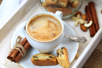 Coffee with milk and sugar and raisin cookies on wooden table