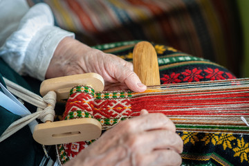 Woman working at the weaving loom. Traditional Ethnic craft of Baltic. - Image