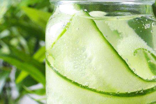 Jar of fresh cucumber water on blurred background, closeup
