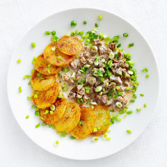 chicken hearts, livers, and stomacks  stewed with sour cream garnished with fried potato and decorated with green onion
