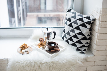 Cozy winter home arrangement on windowsill, coffee and cookies o