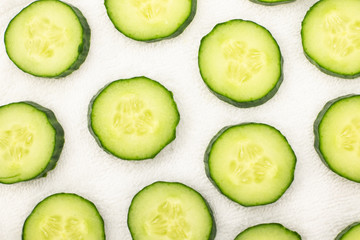 Background from sliced ​​cucumbers on a white towel