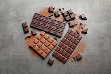 Different kinds of chocolate on grey background, flat lay