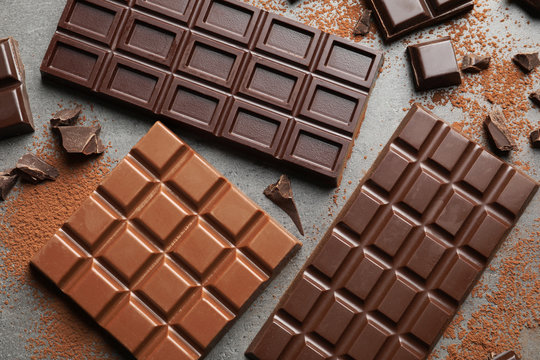 Different kinds of chocolate on grey background, top view