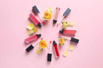 Obraz na płótnie Canvas Composition of lipsticks with flowers on color background, flat lay.