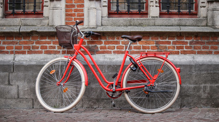 Fototapeta na wymiar Red bicycle with bricks background