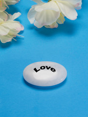 White flowers with a stone that depicts love peace and happiness