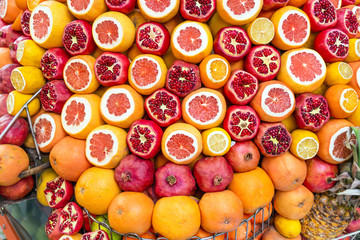 Ripe and juicy half peeled pomegranates, oranges ready to be squeezed for fresh juice. Istanbul, Turkey in summer.