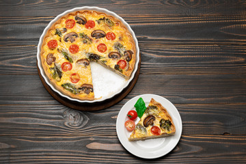 Slice of traditonal homemade spinach chicken quiche tart or pie on plate