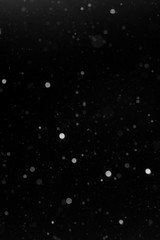 a bokeh of white snow on a black background