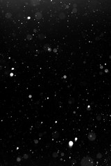 a bokeh of white snow on a black background