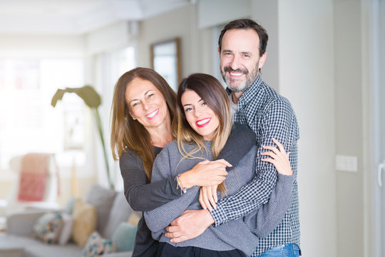 Beautiful family together. Mother, father and daughter smiling and hugging with love at home.