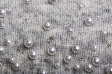 Knitted background. Light gray gentle wool background pattern. Background embroidered with beads