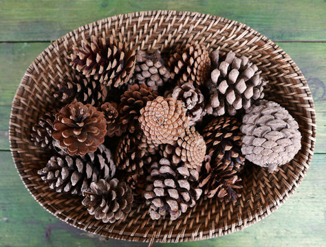 composizione still life di pigne in un cestino su tavolo di legno