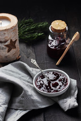 Cherry Jam on wooden background. Dark rustic style, selective focus
