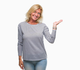 Middle age blonde woman over isolated background smiling cheerful presenting and pointing with palm of hand looking at the camera.