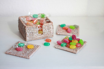 Caramelos de colores en cesta de mimbre