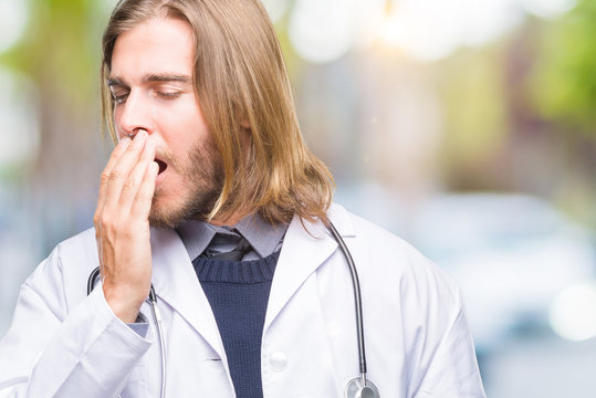 Young handsome doctor man with long hair over isolated background bored  yawning tired covering mouth with hand. Restless and sleepiness. Stock  Photo | Adobe Stock