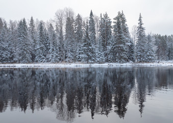 River in winter and tree branches covered with white frost and snow