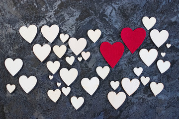 Obraz premium A lot of wooden and two red decorative hearts on black background. Valentine's Day Concept.