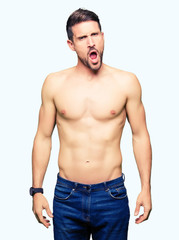 Fototapeta premium Handsome shirtless man showing nude chest In shock face, looking skeptical and sarcastic, surprised with open mouth