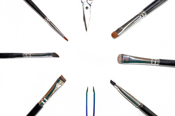 Set tools make-up artist. Isolated set of different makeup artist brushes and scissors lie in a circle with copyspace