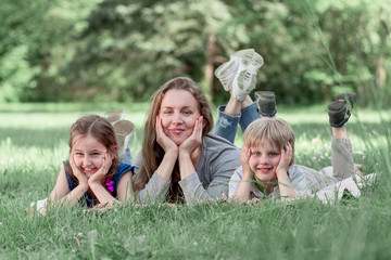 Fototapeta premium funny mom with her kids on the lawn on a summer day
