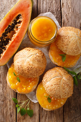 Delicious sandwiches with papaya jam, cream cheese and mint close-up. Vertical top view