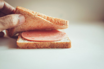 Make sandwich with whole wheat bread and ham. concept make minimal and easy food. vintage color tone