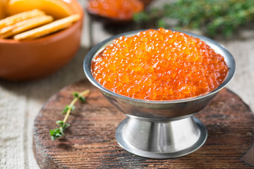 Red caviar in a wooden bowl. Rustic style