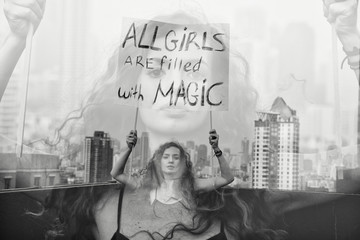 The girl stands on the roof with a poster "All girls are filled with Magic" International Womens Day  concept. 