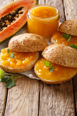 Homemade fresh papaya jam and sesame buns close-up. vertical