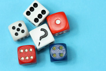 Different dices and question mark on blue background.