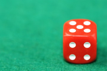 Red dice on green background.