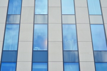 Obraz premium Modern building with reflected sky and cloud in glass window