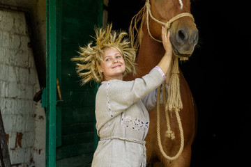 Portrait of a rural woman next to a horse against a dark background.