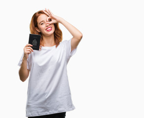 Obraz premium Young beautiful woman holding passport of canada over isolated background with happy face smiling doing ok sign with hand on eye looking through fingers