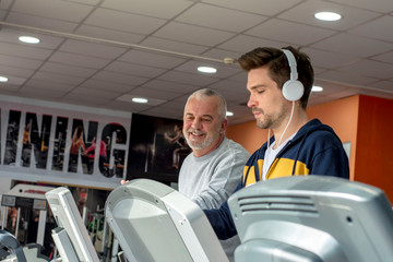 Friends exercising together on a treadmill in the gym