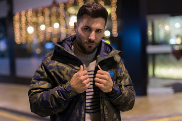 Young handsome man possing and smiling. Street style at night